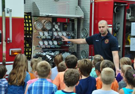 Firefighter showing Fire Engine to children