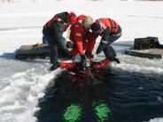 firemen doing cold water training in a frozen lake