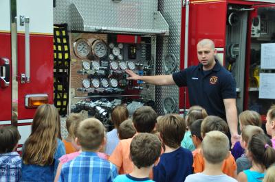 Firefighter showing Fire Engine to children