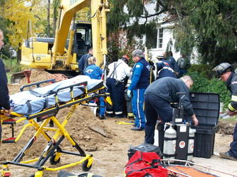 firemen and emts helping someone onto a stretcher