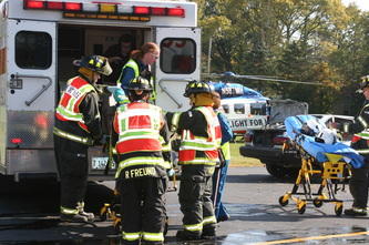 firemen putting someone in an ambulance on a stretcher