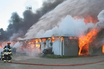 firemen spraying water on a burning building